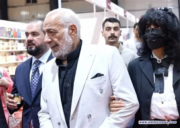 في معرض بغداد للكتاب.. المرأة المقنعة برفقة أيمن زيدان تثير التكهنات